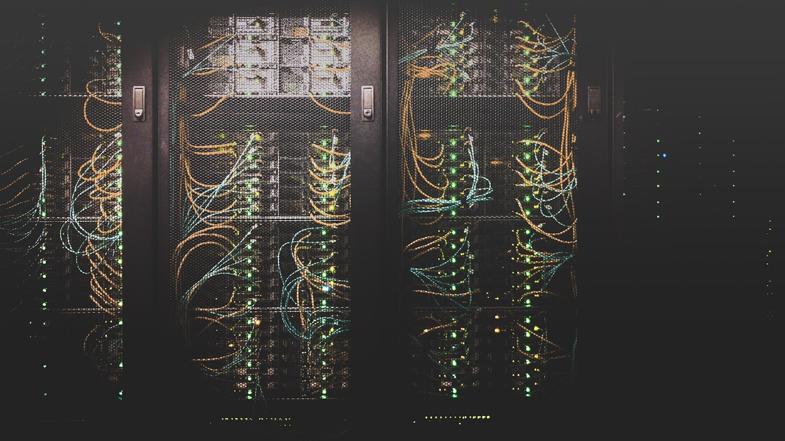 A row of server racks lit by green status lights.